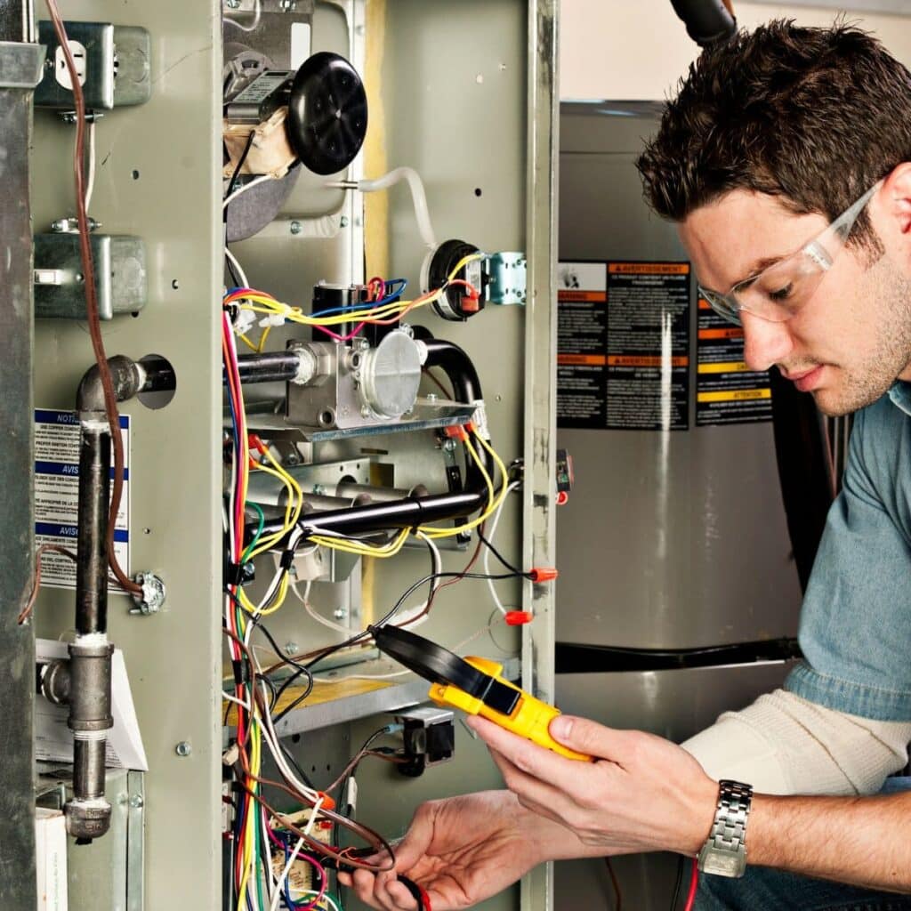 heater technician looking at a pressure reader while performing repairs on a heater