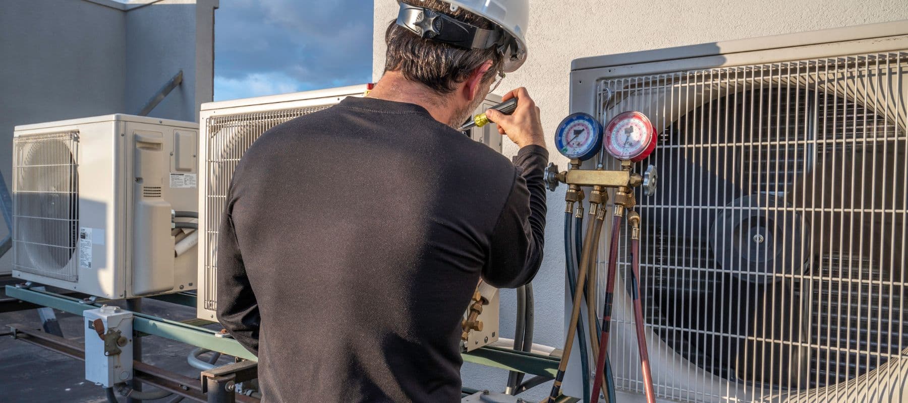 a tech closely inspecting a commercial unit