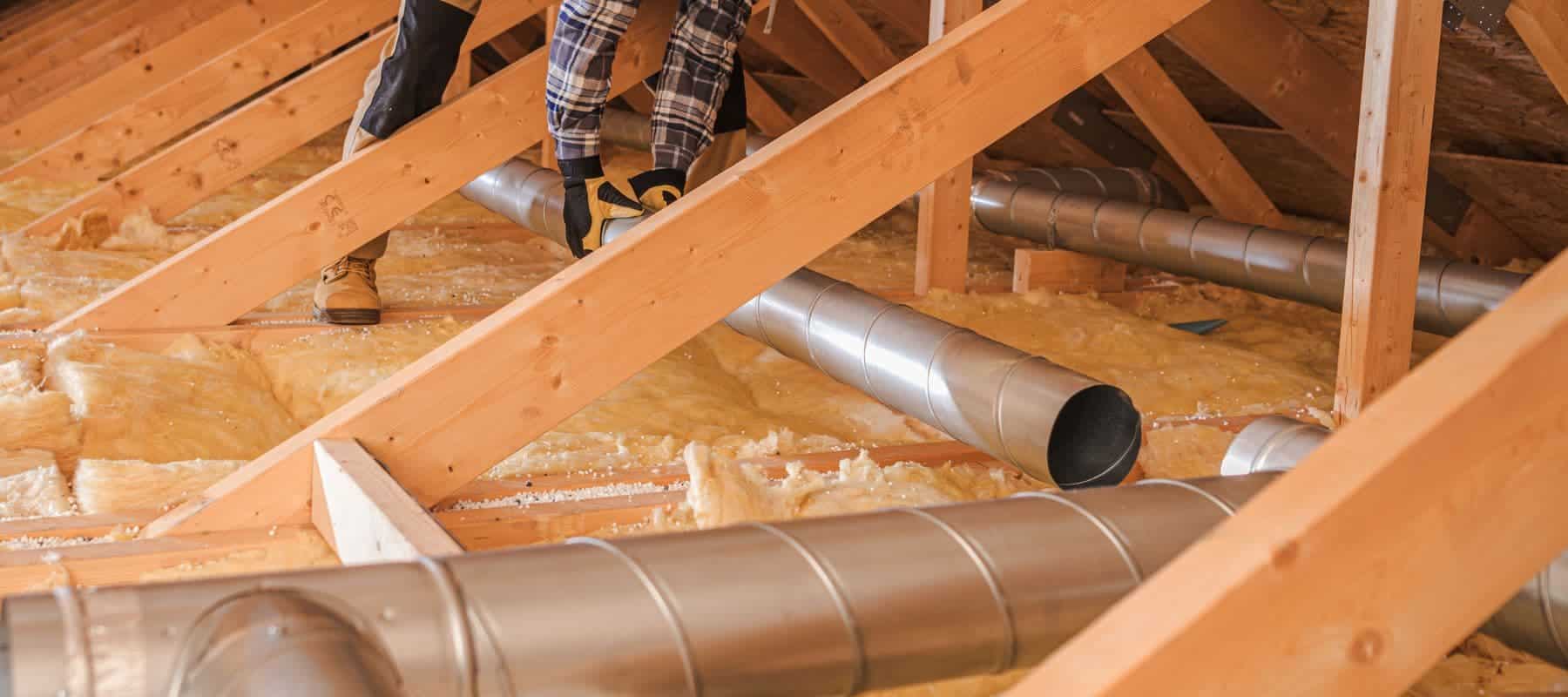 hvac technician holding a large air duct tube connecting it to the rest of them