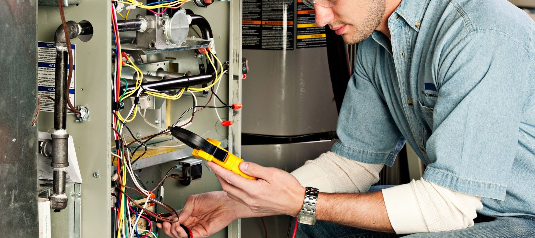 heater technician looking at a pressure reader while performing repairs on a heater