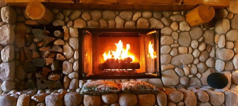fire in a fire place. Rock fire place with a wood mantle