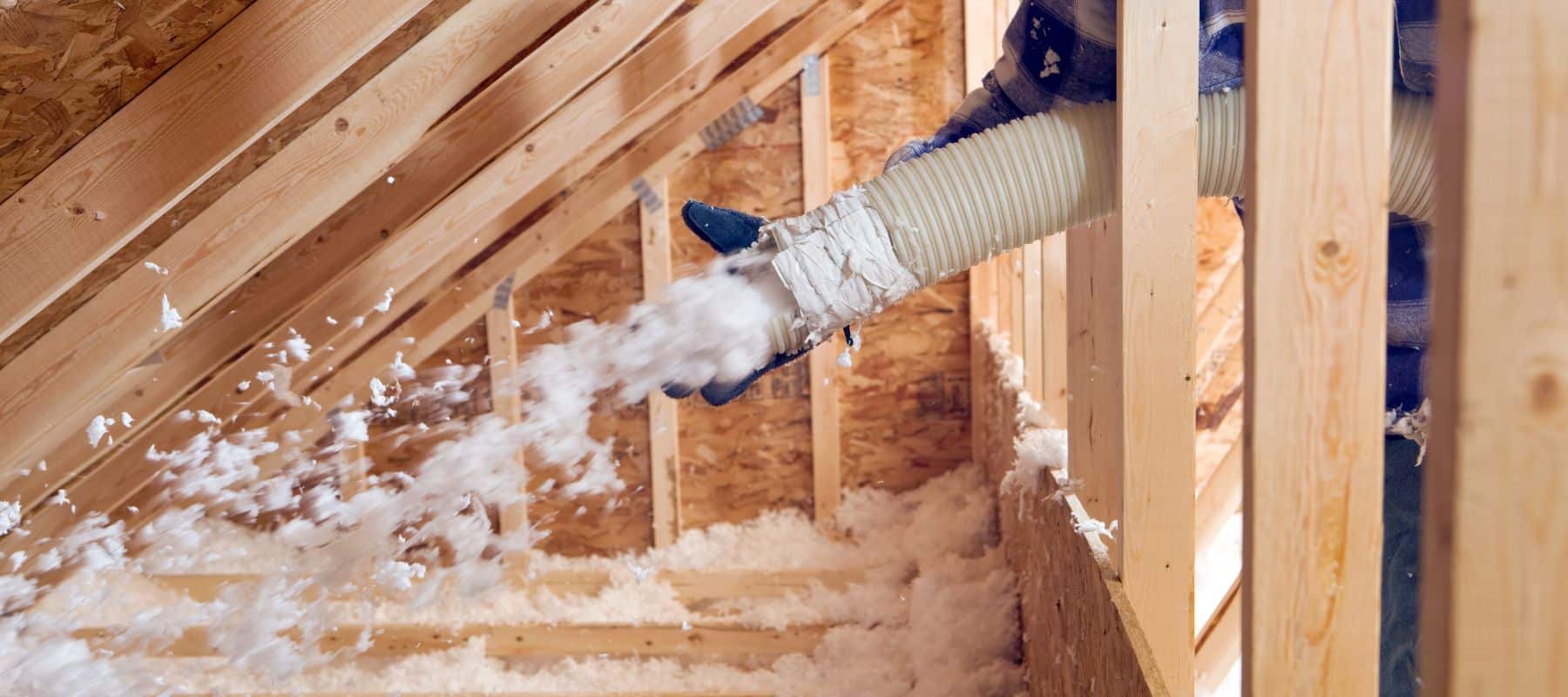 tech blowing in insulation into an attic