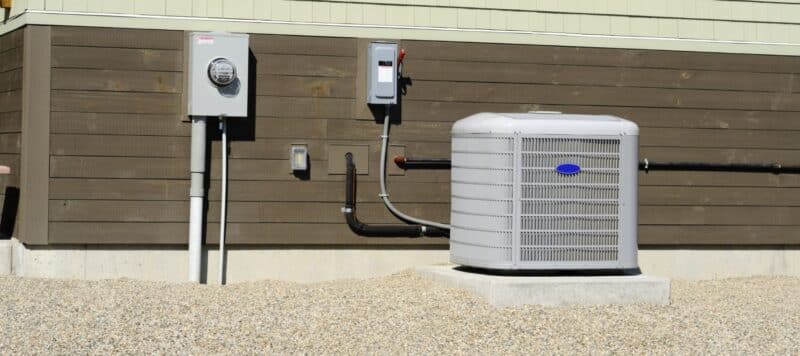 hvac unit outside on the wall against a house