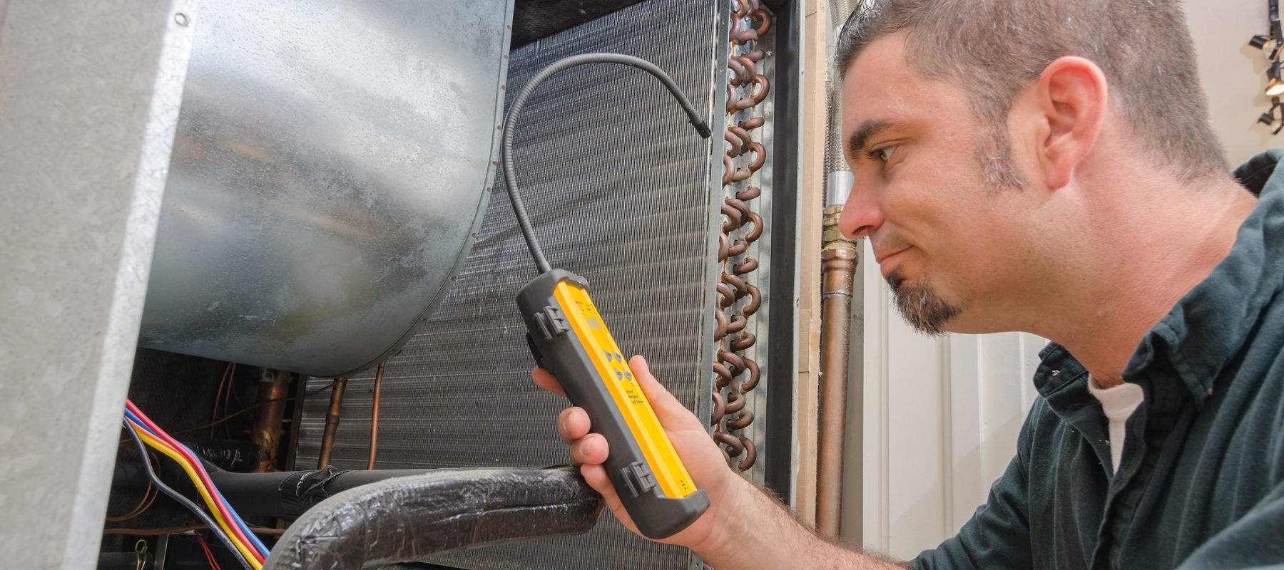 closeup of a hvac technician using a digital pressure reader to perform ac repair